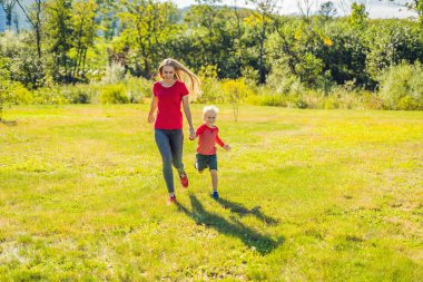 Anne ve oğlu Parkı yeşil çim üzerinde çalışan