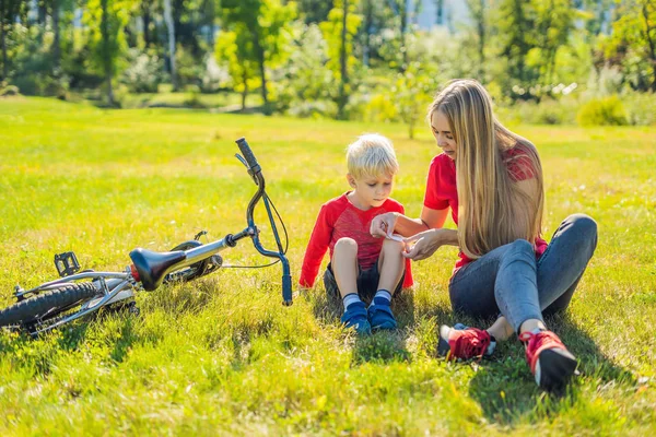 Mom and son resting on lawn after riding bike