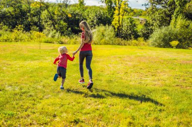 Anne ve oğlu Parkı yeşil çim üzerinde çalışan