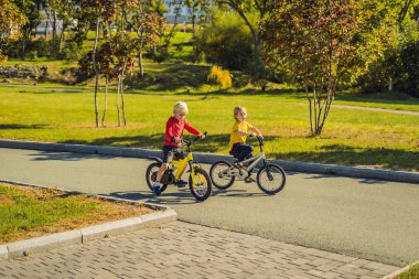 Yeşil parkta güneşli gün bisiklet iki mutlu çocuk