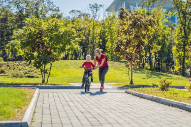 Parkta Bisiklete binmeyi genç anne öğretim oğlu