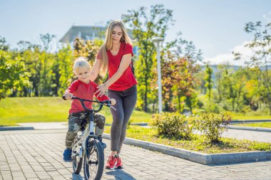 Parkta Bisiklete binmeyi genç anne öğretim oğlu