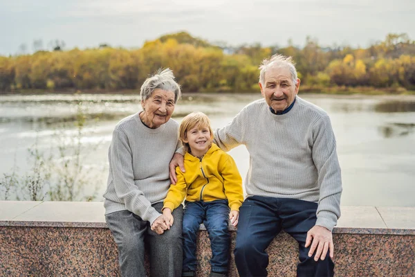 Старшая пара с внуком в осеннем парке. Прабабушка, прадедушка и правнук — стоковое фото