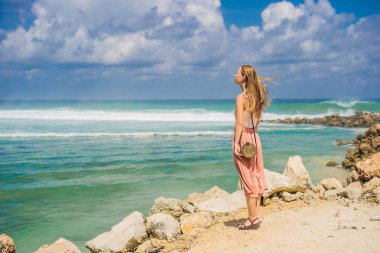 Rüzgarlı havalarda Bali Adası, Endonezya kumsalda Melasti şaşırtıcı üzerinde yürüyen genç kadın gezgin.