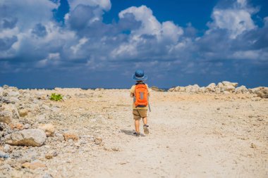 Turkuaz su, Bali Adası, Endonezya Melasti kumsalda yürüyen turist sırt çantası çocukla.