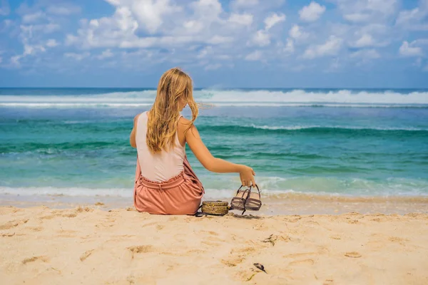 砂の上に座って素晴らしいメラスティ ビーチ バリ島 インドネシアの青緑色の水の景色を楽しみながら若い女性 — ストック写真