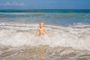 Küçük çocuk egzotik kıyı şeridi okyanus dalga oynamak.