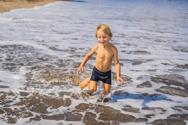 海の水の海岸線上で楽しんで少年 — ストック写真