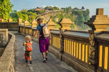 Baba ve oğul Pura Luhur Uluwatu Tapınağı, Bali, Endonezya gezisinde sırt çantaları ile. 