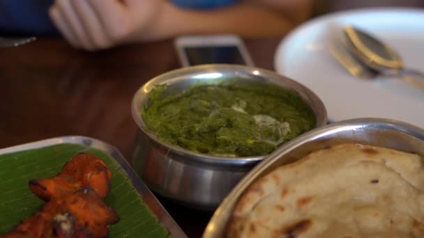 Ung kvinna och hennes familj äter indisk mat i café — Stockvideo