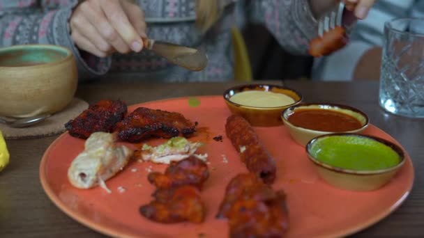 Slowmotion tiro de mulher jovem e sua família comer comida indiana no café — Vídeo de Stock