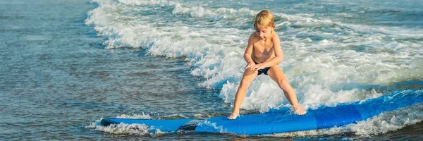 在热带海滩上冲浪的小男孩 孩子在海浪上冲浪板上 积极的水上运动为孩子们 孩子用冲浪游泳 给孩子们上冲浪课 长格式 — 图库照片
