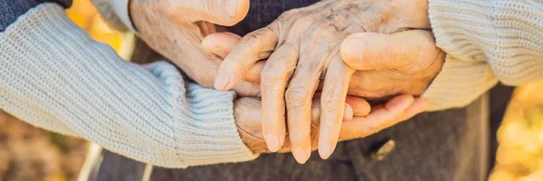 Bejaarde echtpaar hand in hand in de herfst park Banner, lange notatie — Stockfoto