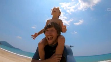 Phuket, Tayland - 12 Ekim: Slowmotion kadeh bir genç baba ve oğul onlar üzerinde uçan bir uçak ile. Mai Khao Beach Phuket Adası