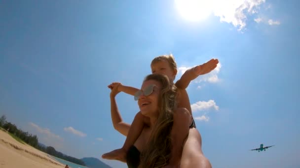 Tikje schot van een jonge vrouw en haar zoon met een vliegtuig vliegen over hen. Mai Khao Beach Phuket eiland — Stockvideo