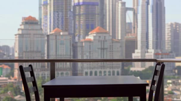 Joven institutriz preparando el desayuno en un balcón con vistas a los rascacielos del centro de la ciudad — Vídeos de Stock