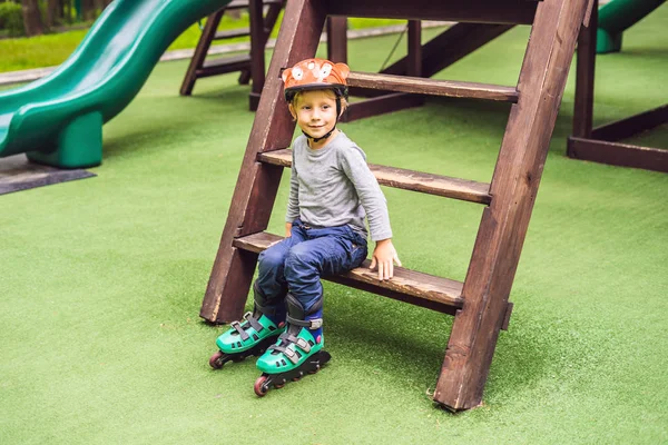 Junge Mit Rollschuhen Und Helm Sitzt Auf Spielplatz — Stockfoto