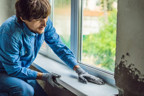 Genç teknisyen pencere montaj yaparken rahat gömlekli.