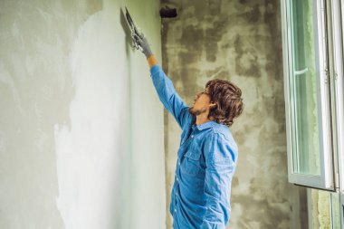 Duvar ve macun bıçak tarafından bulaşması beyaz macun uygulayarak erkek işçi.
