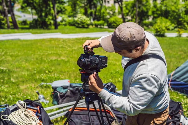 Un operatore professionista prepara una macchina fotografica e un treppiede prima di scattare — Foto Stock