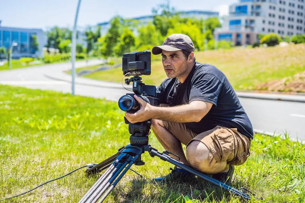 Un operatore professionista prepara una macchina fotografica e un treppiede prima di scattare — Foto Stock