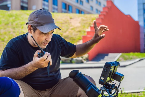 Processus de tournage sur scène de cinéma - plateau de production commerciale, emplacement extérieur.Caméraman professionnel exploite la caméra — Photo