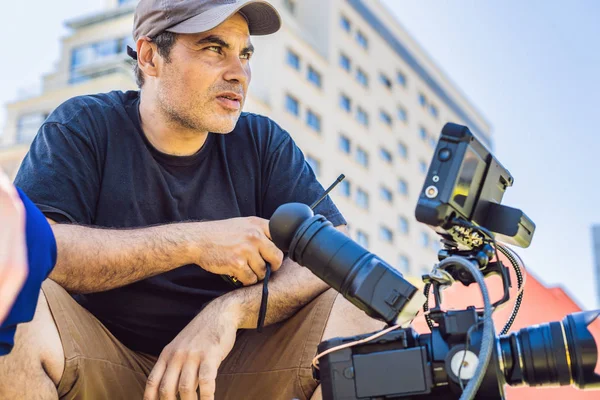 Processus de tournage sur scène de cinéma - plateau de production commerciale, emplacement extérieur.Caméraman professionnel exploite la caméra — Photo