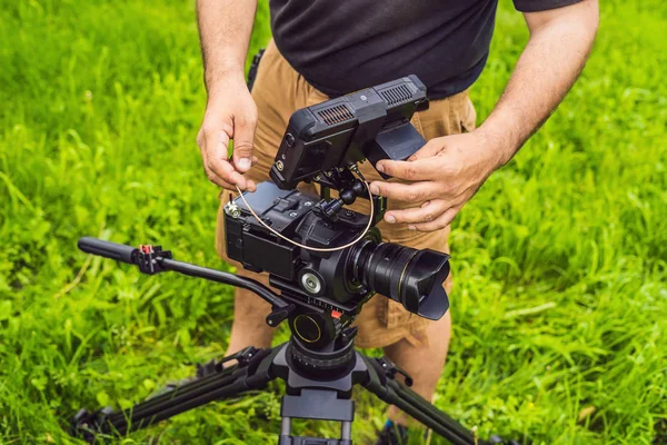 Ein professioneller Kameramann bereitet vor dem Dreh eine Kamera und ein Stativ vor — Stockfoto