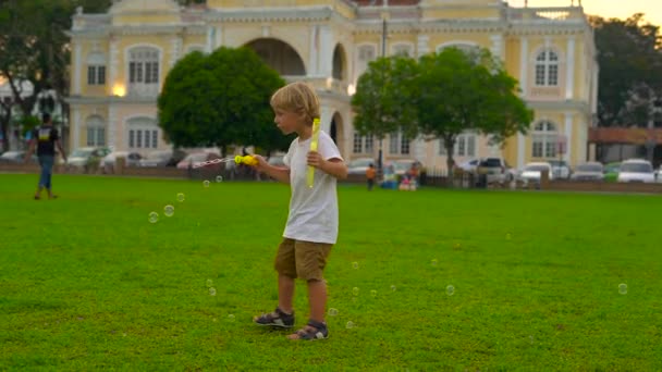 在槟城岛格鲁吉亚城城门前的市政厅前广场上 一个小男孩在广场上玩泡泡吹风机的缓慢镜头 — 图库视频影像