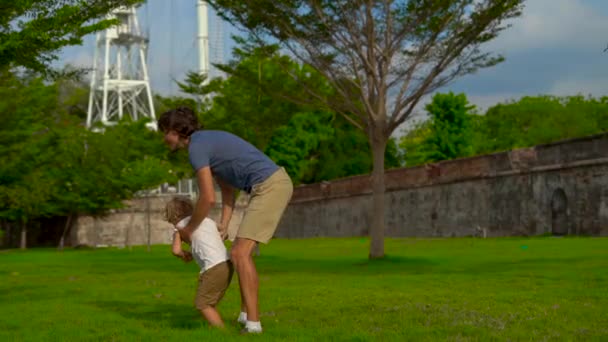 Slowmotion lövés egy apa és fia, séta és játék: a Fort Cornwallis, Malajzia, a Penang szigeten — Stock videók