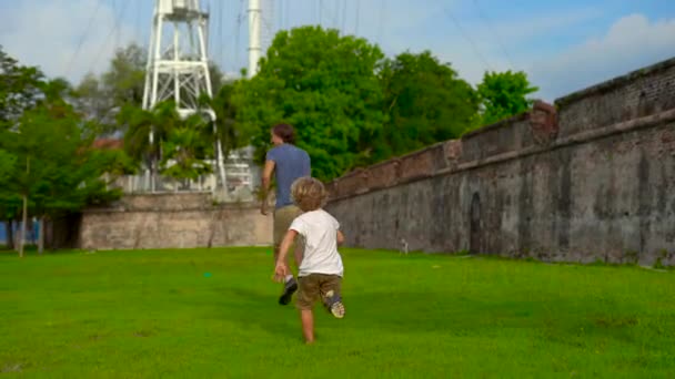Tikje shot van een vader en zoon wandelen en spelen op het Fort Cornwallis op het eiland Penang, Maleisië — Stockvideo