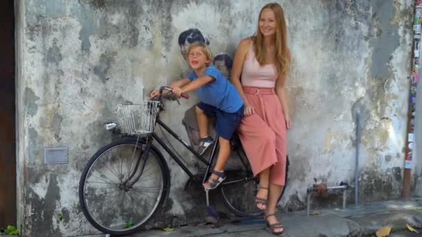 Mor och son på en cykel. Offentlig gatukonst i Georgetown, Penang, Malaysia — Stockvideo