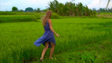 Bir güzel pirinç alan kenarında yürüyen genç bir kadın görüntüsünü Slowmotion