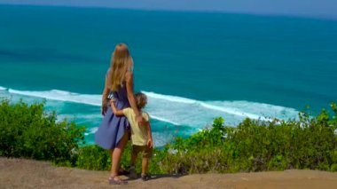 Genç bir kadın ve oğlu okyanusa bakarak uçurumun kenarında ayakta Slowmotion vurdu. Suluban ve Florida'da Florida'da yer. Çocuklar kavramı ile seyahat