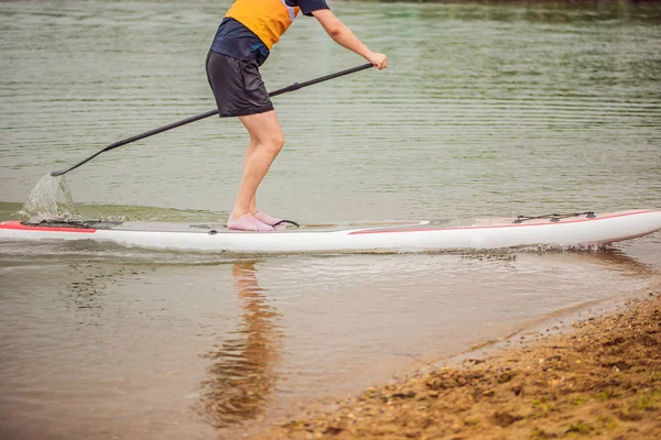 Hombres en una tabla de SUP en el río o en el mar —  Fotos de Stock