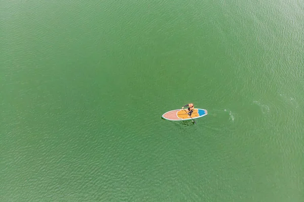 ギリシャの水スポーツ競争しながらベイで Sup のボードに浮かぶ人の空撮 — ストック写真