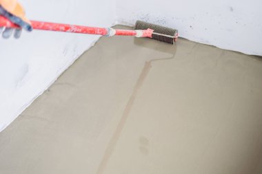 Sıvacı döşeme sırasında kendi kendine çimento harçlı tesviye ile çalışır