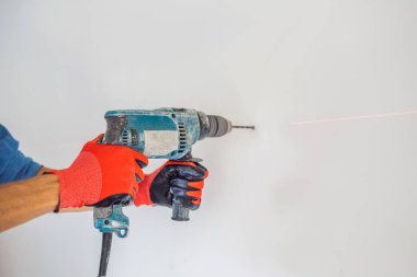 Erkek Close-up yapım hole beton duvar ile profesyonel matkap eller..