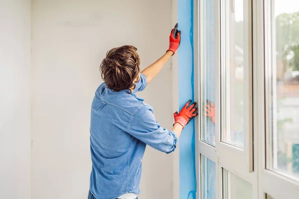 Mann Befestigt Blaues Klebeband Bei Fenstermontage — Stockfoto