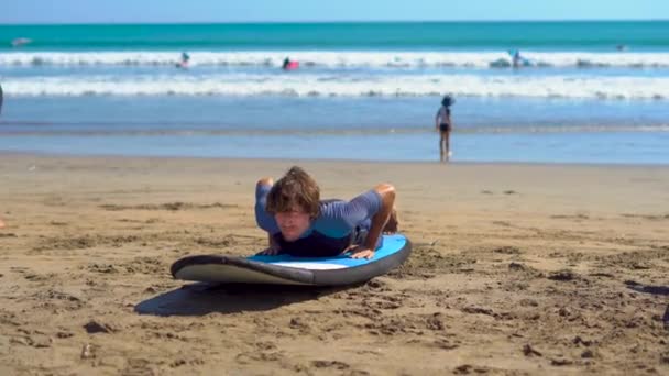 Νεαρός άνδρας λαμβάνοντας μια εκπαίδευση σέρφινγκ στην παραλία — Αρχείο Βίντεο