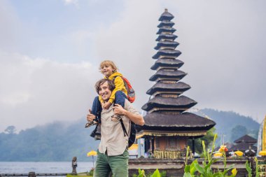 Baba ve oğul Pura Ulun Danu Bratan, Bali arka planda. Hindu Tapınağı çiçek Bratan Gölü, Bali çevrili. Shivaite su Tapınağı Bali, Endonezya Binbaşı. Hindu Tapınağı. Çocuk kavramı ile seyahat.