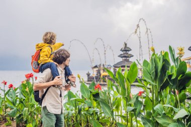Baba ve oğul Pura Ulun Danu Bratan, Bali arka planda. Hindu Tapınağı çiçek Bratan Gölü, Bali çevrili. Shivaite su Tapınağı Bali, Endonezya Binbaşı. Hindu Tapınağı. Çocuk kavramı ile seyahat.