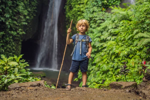 Мальчик с тростью на фоне водопада Лике-Леке на острове Бали в Индонезии. Путешествие с детской концепцией — стоковое фото
