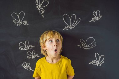 Komik yüz ifadesi ve gözümün önünde blackboard ile çizilmiş tebeşir sivrisinek sokması ile küçük çocuk. 