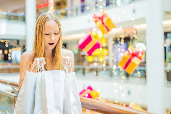 圣诞装饰商场内拿着购物袋的年轻女子 — 图库照片