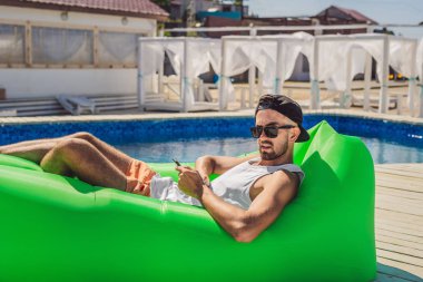 Boş zaman zevk, havuz kenarında hava Divan Lamzac, yalan genç adam