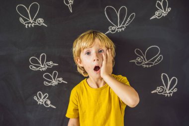 Komik yüz ifadesi ve gözümün önünde blackboard ile çizilmiş tebeşir sivrisinek sokması ile küçük çocuk. 