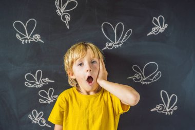 Komik yüz ifadesi ve gözümün önünde blackboard ile çizilmiş tebeşir sivrisinek sokması ile küçük çocuk. 