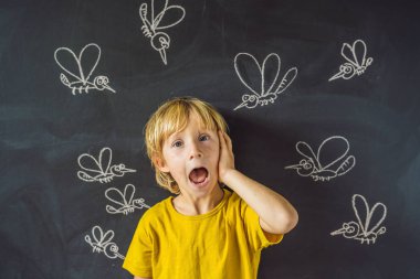 Komik yüz ifadesi ve gözümün önünde blackboard ile çizilmiş tebeşir sivrisinek sokması ile küçük çocuk. 