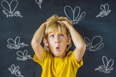 Komik yüz ifadesi ve gözümün önünde blackboard ile çizilmiş tebeşir sivrisinek sokması ile küçük çocuk. 